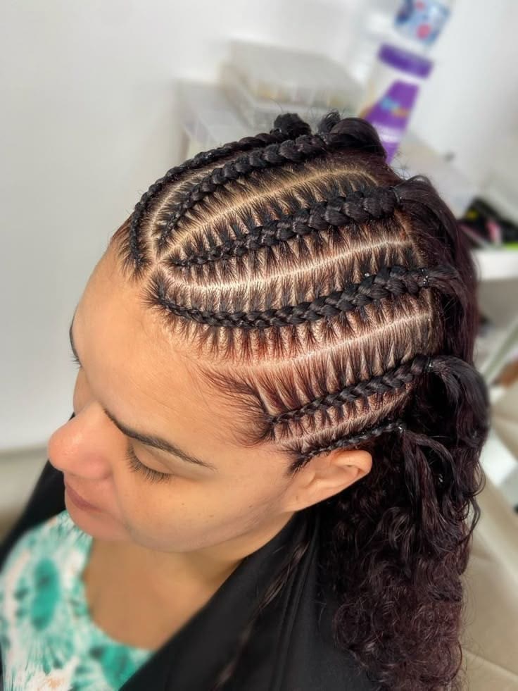 Close view of neat cornrow partings being braided, half of the hair still loose.