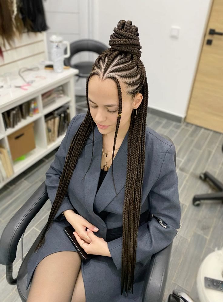 Fulani-style braids gathered into a sculpted high bun, with long lengths falling in front.