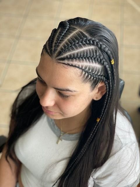Side-swept lemonade cornrows finished with gold beads, flowing into loose lengths.